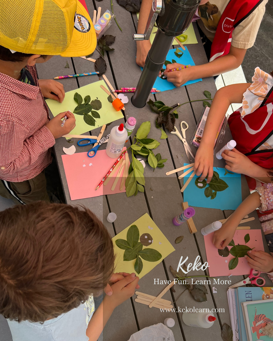 Children arranging leaves into artwork outdoors at Keko