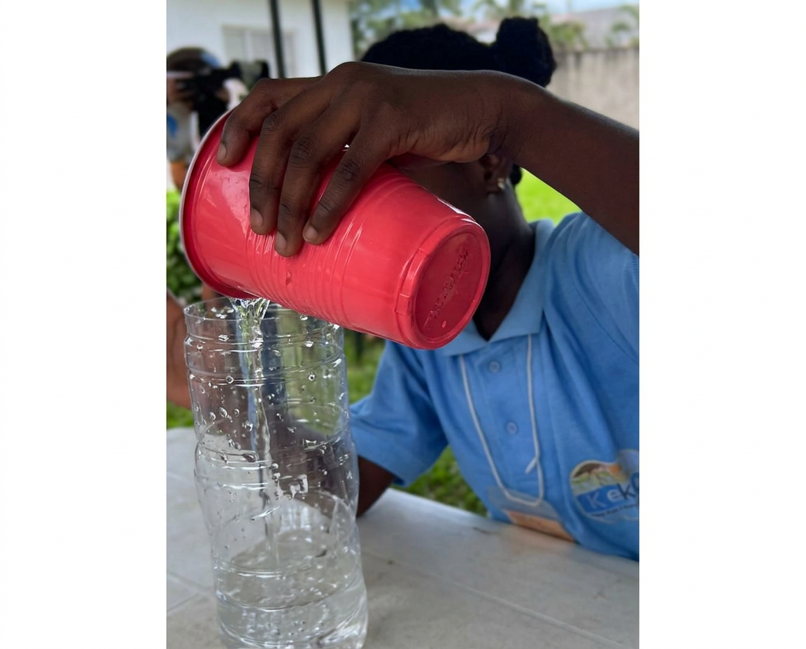 Child pouring water from a cup into a bottle at Keko summer camp